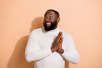 Photo of positive dreamy guy wear white sweater arms together looking empty space isolated beige...