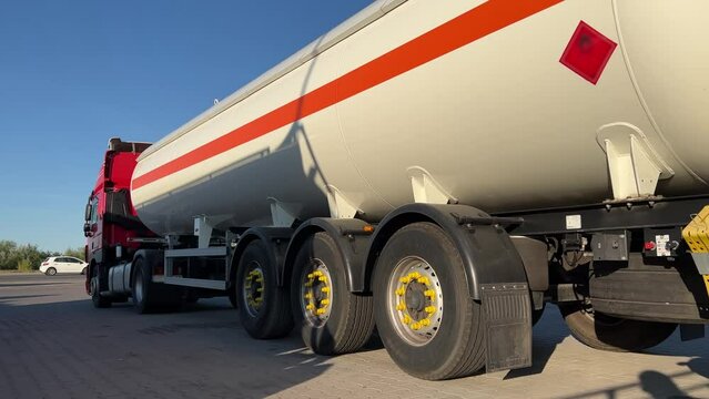 Gasoline truck stands in the parking lot of the oil depot, waiting for the tanks to be filled and the subsequent delivery of fuel to the gas station. Back view. Wide angle shot