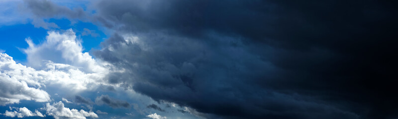 Obraz premium White and dark blue storm clouds, contrast sky. Panoramic view of beautiful dramatic sky