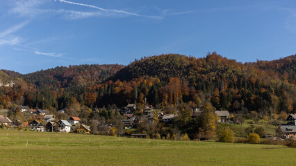 Fototapeta na wymiar autumn village landscape hills covered by forest