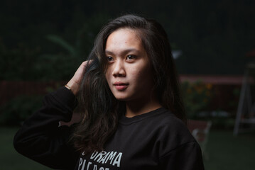 Asian young woman who wants to express something with expression. Asian female model wearing black t-shirt on bokeh background.