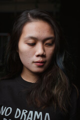 Fototapeta premium Asian young woman who wants to express something with expression. Asian female model wearing black t-shirt on bokeh background.
