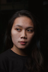 Fototapeta premium Asian young woman who wants to express something with expression. Asian female model wearing black t-shirt on bokeh background.