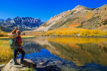 A backpacker enjoying  fall colors reflection of North Lake near Bishop in Eastern Sierra, California