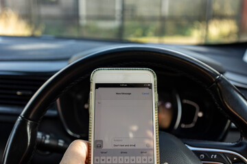 dont text and drive, mobile phone held whilst driving car, danger concept, copy space
