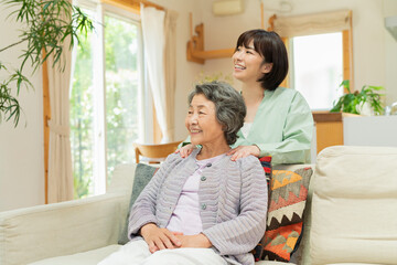 祖母の肩を揉む30代女性