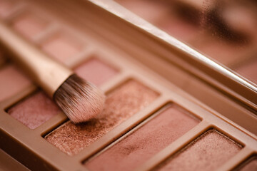 Eye shadow palette in pink rose gold and nude colors closeup. Makeup cosmetic product. Selective focus.