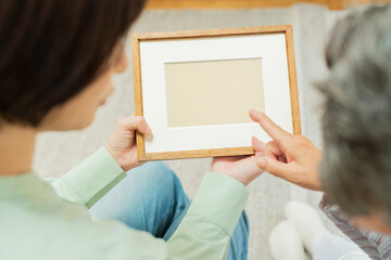 孫と写真を見るシニア女性