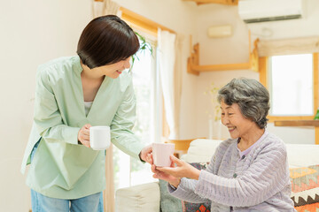 Obraz premium 自宅 一緒にお茶を飲む祖母と孫