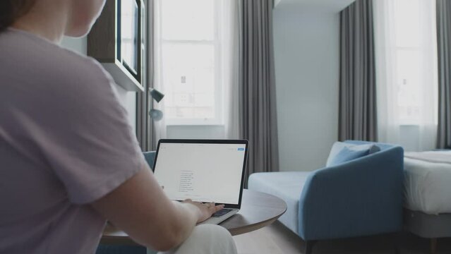 Cliente dans une chambre d'hôtel avec un ordinateur portable