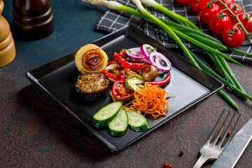 grilled vegetables on black plate on dark stone table