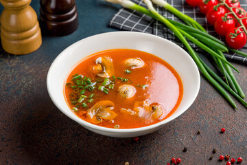 mushroom soup in a plate on dark stone table