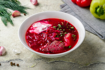 Borscht with sour cream and beef on stone table