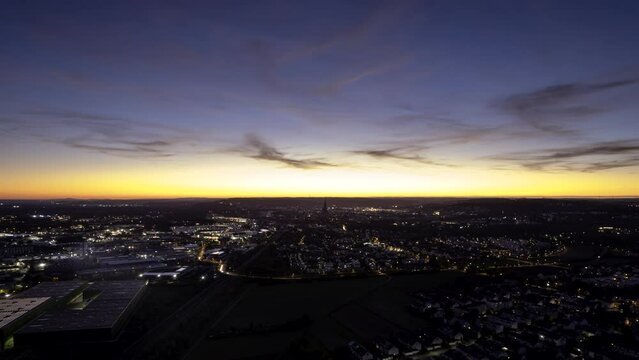 Aerial time lapse shot of the cities of Neu-Ulm and Ulm with Ulm Minster while colorful dusk seen from hill in city part &bdquo;Pfuhl&ldquo; of Neu-Ulm (Kapellenberg)