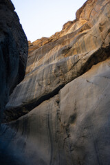 Sunrise light on curved canyon wall in desert