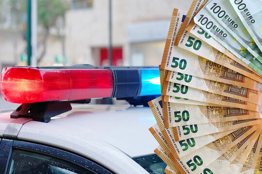 Euro notes banknotes and close-up of the blue and red lights on top of a police vehicle. Concept bribe and corruption in police in Europe