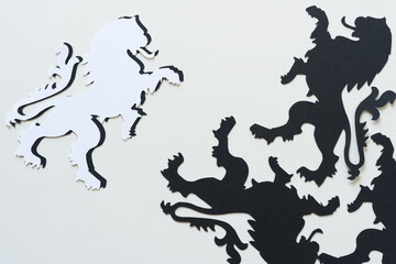 paper glyphs or dingbats in the shape of heraldic lions arranged on paper
