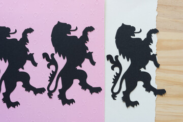 heraldic lion glyphs or dingbats on embossed and plain paper and wood background