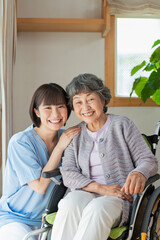 Obraz premium 女性医療従事者と車椅子に乗ったシニア女性