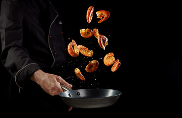 Crop faceless chef throwing shrimps in pan during dinner preparation