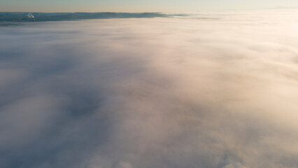 Fototapeta na wymiar Sun, Early Sunrise and Horizon over a clouds cover mountains ridge and pipe plant