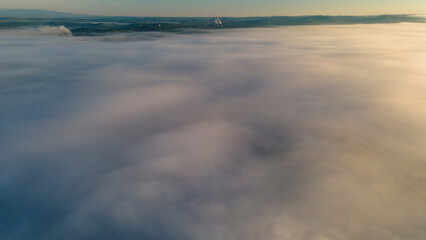 Fototapeta na wymiar Sun, Early Sunrise and Horizon over a clouds cover mountains ridge