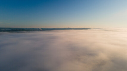 Fototapeta premium Sunbeam, Sunrise and Horizon over a clouds cover mountains ridge and pipe plant