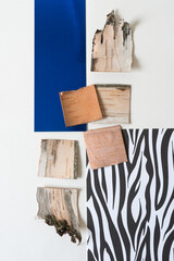 abstract composition with pieces of cut birch bark, blank and blue paper, and paper with white and black stripes (or prints)