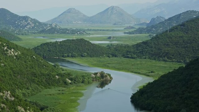 Boat on beautiful river Rijeka Crnojevica between mountains flowing into Skadar Lake, Montenegro, 4k