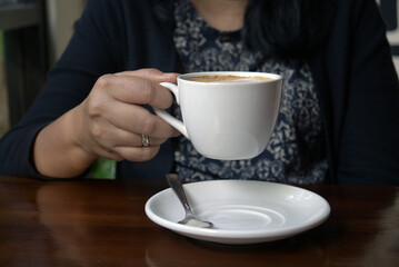 Close up of a woman's hand holding a cup of coffee