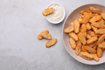 Crispy rusks and dip sauce on light table, flat lay. Space for text