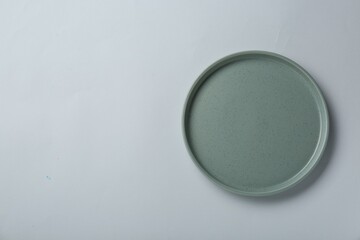 Clean plate on light grey background, top view. Space for text