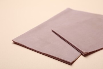 Pink reusable beeswax food wraps on beige background, closeup