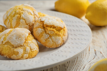 Delicious lemon cookies and citrus fruits on white wooden table, closeup