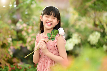 Romantic beauty girl holding rose in garden
