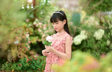 Romantic beauty girl holding rose in garden