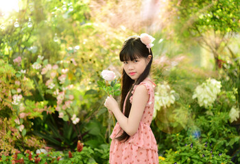 Romantic beauty girl holding rose in garden