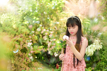 Romantic beauty girl holding rose in garden