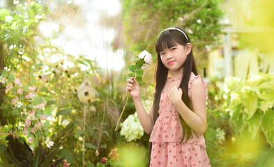 Romantic beauty girl holding rose in garden