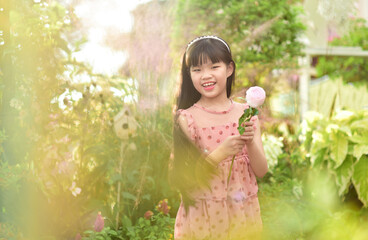 Romantic beauty girl holding rose in garden