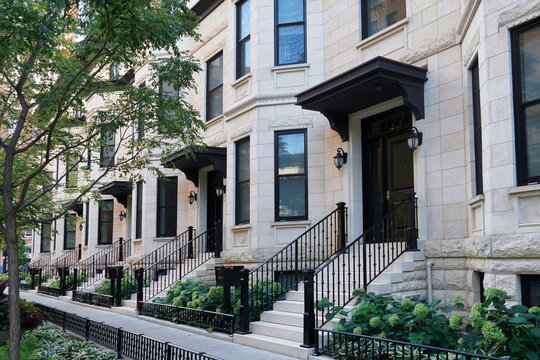 Row of urban townhouses with light colored stone front