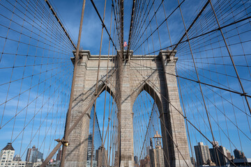 Brooklyn Bridge suspension tower and cables, with the Brooklyn skyline as a backdrop