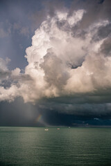 Naklejka na ściany i meble Rainbow and yacht under a storm cloud