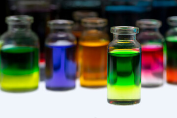 Colored water in small glass containers on white background