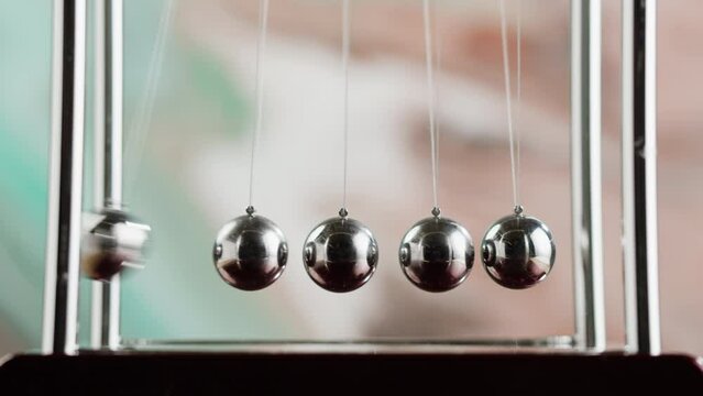Newton balls close-up, five metallic pendulums colliding, cradle. Physics and science concept.