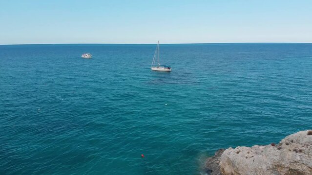 In Europa EU Italien auf der Insel Sardinien mit einem Schiff und Segelboot auf dem Meer am Kliff und Strand 4k