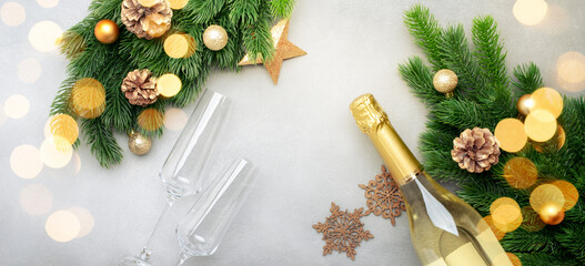 Christmas festive background with champagne bottle and wine glasses, golden christmas balls, fir...