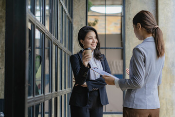 Two Asian business women discussing new business project with laptop in meeting in modern office. casual business idea