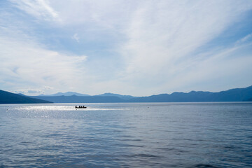 北海道 支笏湖の湖と青い空・湖面に浮かぶカヌー