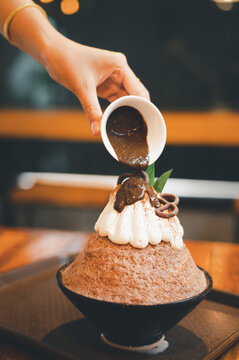 Hand taking a fruit ball from Bingzu korean shave ice, Woman diet with healthy eating concept.